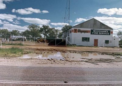 Mid 1980's tyre and fuel depot front view water on side road