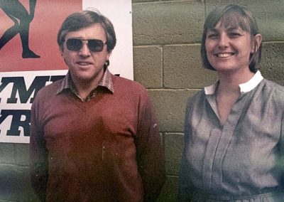 Jim and Maria Woodham - Lady and man standing in front of brick wall